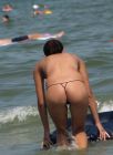 brunette-in-string-bikini-topless-on-beach