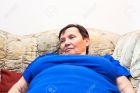 18136585-Close-up-of-obese-elderly-woman-lying-on-sofa--Stock-Photo-older
