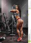 fille-de-forme-physique-femme-sportive-sexy-établissant-avec-le-barbell-dans-le-gymnase-beau-cul-sexy-dans-la-lanière-69211398