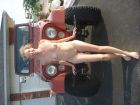 Nudist_woman_posing_in_front_of_Jeep_CJ7